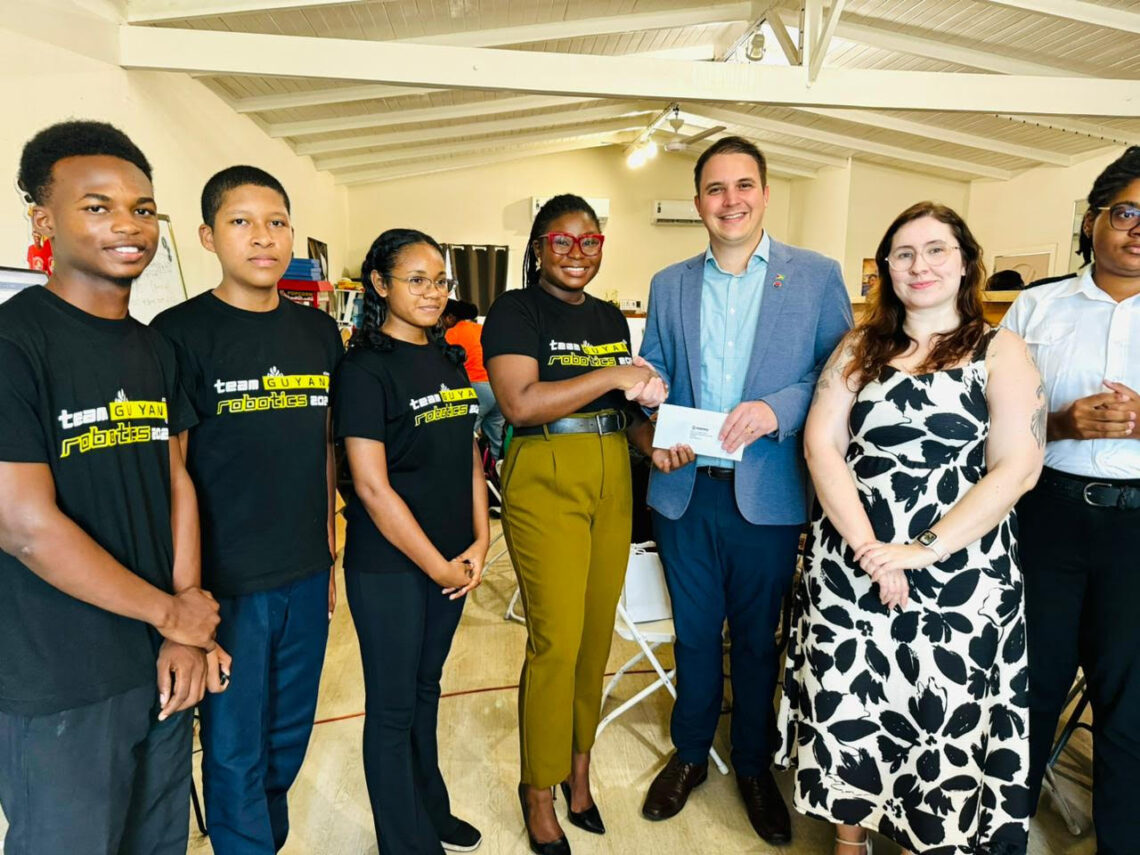 STEMGuyana Board Member & Fundraising Coordinator Elsie Harry receives sponsorship contribution from MODEC Country Manager Rafael Fumis