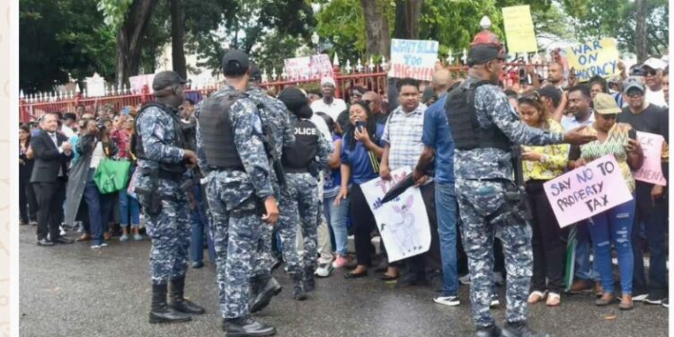 Police officers ask protestors to stand on the pavement during their demonstration outside the Red House before the Budget Presentation yesterday. (Kervin Pierre photo, T& T Guardian)