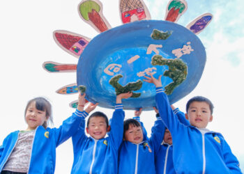 Children from a kindergarten in Huzhou, Zhejiang Province, hold up an artwork sharing the message of a single shared Earth on April 22 (XINHUA)