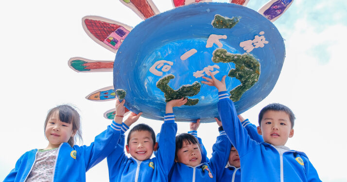 Children from a kindergarten in Huzhou, Zhejiang Province, hold up an artwork sharing the message of a single shared Earth on April 22 (XINHUA)