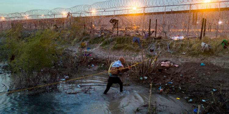 A Venezuelan immigrant walks through the Rio Grande as he crosses the U.S.-Mexico border. President-elect Donald Trump has promised to make it harder for people to enter the United States illegally. | John Moore/Getty Images