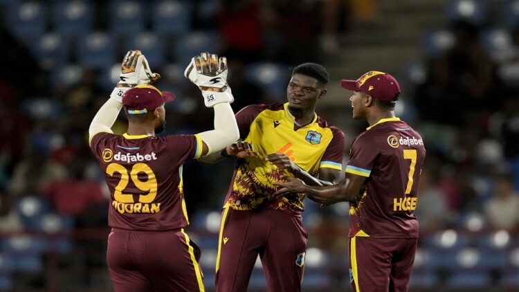 West Indies' Alzarri Joseph, center, celebrates with teammates Nicholas Pooran and Akeal Hosein the dismissal of England's captain Jos Buttler during the third T20 cricket match at Daren Sammy National Cricket Stadium in Gros Islet, St. Lucia, Thursday, Nov. 14, 2024. (AP Photo/Ricardo Mazalan)