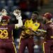 West Indies' Alzarri Joseph, center, celebrates with teammates Nicholas Pooran and Akeal Hosein the dismissal of England's captain Jos Buttler during the third T20 cricket match at Daren Sammy National Cricket Stadium in Gros Islet, St. Lucia, Thursday, Nov. 14, 2024. (AP Photo/Ricardo Mazalan)