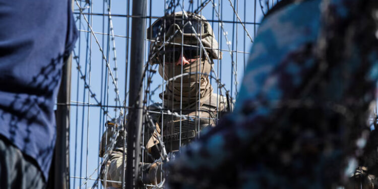 [1/3]A Texas law enforcement officer stands guard at the border as migrants cross from Mexico into El Paso, Texas, U.S., March 22, 2024. REUTERS/Justin Hamel/File Photo Purchase Licensing Rights