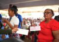 A resident from Region Nine with her cheque yesterday. (Office of the Prime Minister photo)