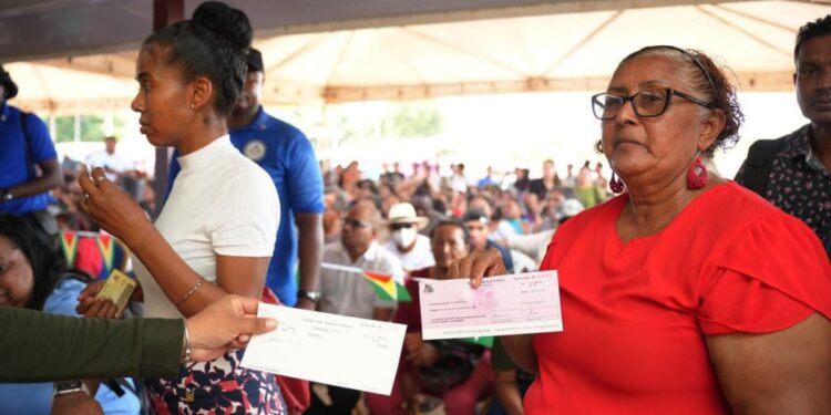 A resident from Region Nine with her cheque yesterday. (Office of the Prime Minister photo)