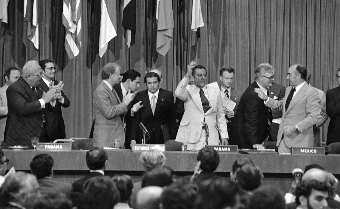 President Jimmy Carter applauds as General Omar Torrijos waves after signing and exchance of treates in Panama City on June 16 1978 giving control of the Panama Canal to Panama in 2000. At far right is national security adviser Zbigniew Brzezinski (AP file photo)