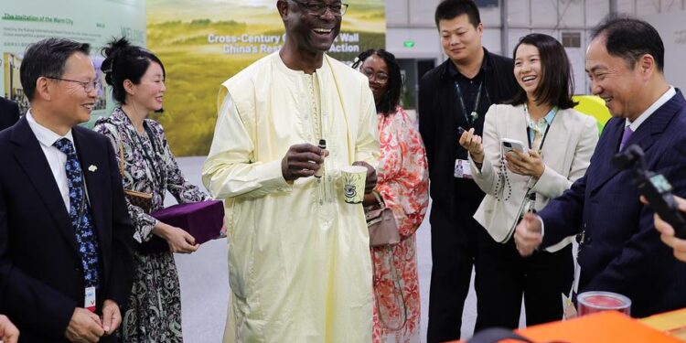 Ibrahim Thiaw (C), executive secretary of the United Nations Convention to Combat Desertification (UNCCD), tastes goji berry juice when visiting the China Pavilion at the 16th Conference of the Parties (COP16) to the UNCCD held in Riyadh, Saudi Arabia, Dec. 6, 2024. (Xinhua/Wang Dongzhen)