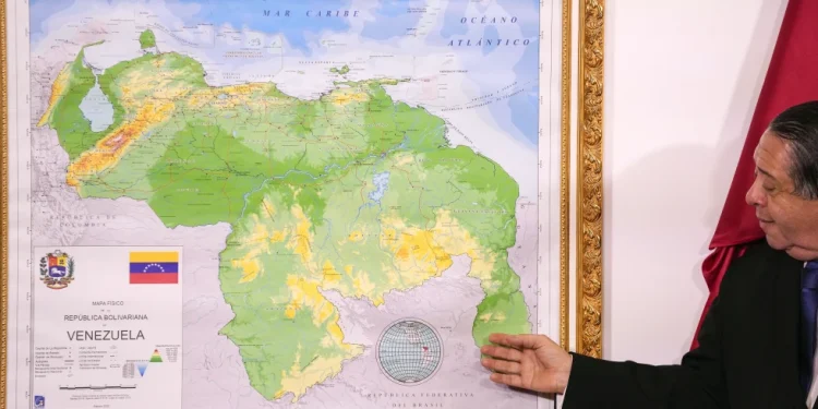 Chairman of the Special Commission for the Defense of Guyana Essequibo Hermann Escarra, stands next to Venezuela’s new map that includes the Essequibo territory, a swath of land that is administered and controlled by Guyana but claimed by Venezuela, during an unveiling ceremony in Caracas, Venezuela, Dec. 8, 2023. (AP Photo/Matias Delacroix, File)