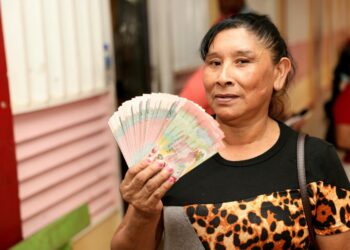 A Guyanese forced to show she is the recipient of the cash grant (17/12/2024) which a strategy employed by the PPP Govt for electioneering purpose. (DPI Photo)