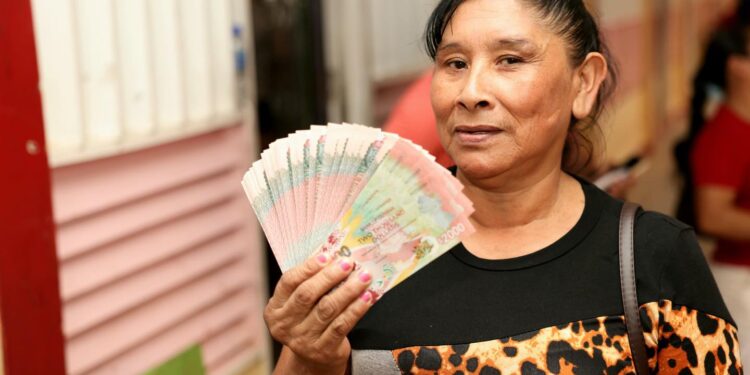 A Guyanese forced to show she is the recipient of the cash grant (17/12/2024) which a strategy employed by the PPP Govt for electioneering purpose. (DPI Photo)