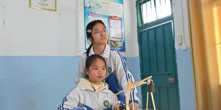 (240126) -- NANNING, Jan. 26, 2024 (Xinhua) -- Students Huang Lichen (L) and Huang Qiuhui perform an experiment in Qianjiang Middle School in Laibin City, south China's Guangxi Zhuang Autonomous Region, Dec. 28, 2023.
  TO GO WITH "China Focus: Igniting passion for science education among rural children" (Xinhua/Zhou Hua)