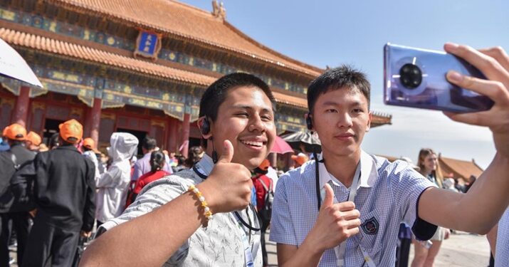 A student (L) of the Muscatine High School delegation takes selfies at the Palace Museum in Beijing, capital of China, on April 18, 2024 (XINHUA)