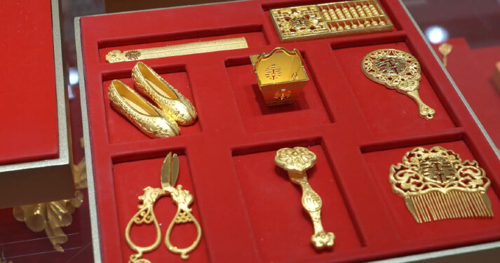 Traditional dowry items reimagined in gold at a Caibai Jewelry store in Beijing on December 4, 2024 (ZHANG WEI)