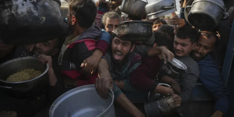 Palestinians struggle for food at a distribution center in Khan Younis, Gaza Strip, Jan. 9, 2025. (AP Photo/Abdel Kareem Hana, File)