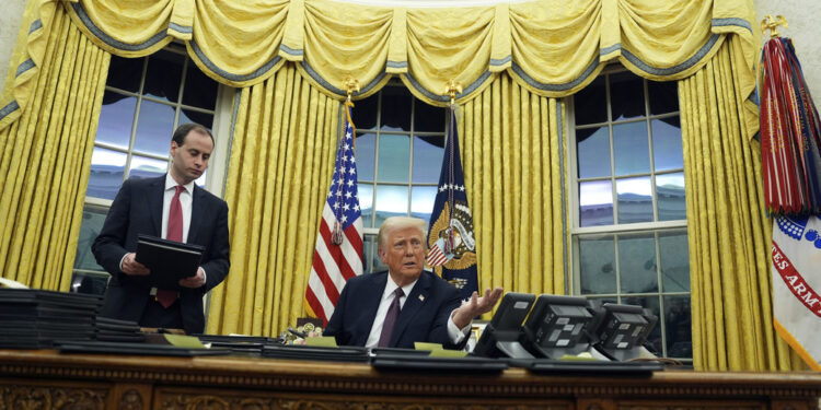 President Donald Trump signs an executive order withdrawing the U.S. from the World Health Organization in the Oval Office of the White House, Monday, Jan. 20, 2025, in Washington. (AP Photo/Evan Vucci)