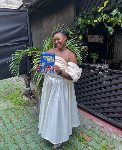 Shanté Smith poses with a copy of her book