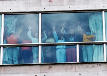 People holding hands on Feb. 18 at a hotel in Panama City where migrants from Asia and the Middle East were housed after being deported from the United States.Enea Lebrun / Reuters file