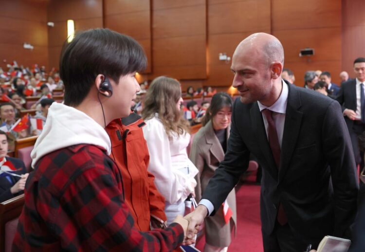 French Minister for Europe and Foreign Affairs Jean-Noel Barrot greets a student at Beijing Language and Culture University on Thursday. Barrot began a two-day visit to China on Thursday. Zou Hong / CHINA DAILY