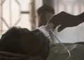 A relative adjusts a tuberculosis patient's oxygen mask in Hyderabad, India, in 2018.Mahesh Kumar A. / AP