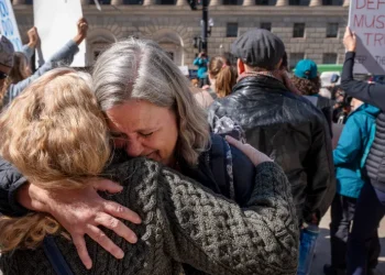 Lane Pollack, center, of Rockville, Md., a senior learning advisor at USAID for 14 years, is consoled by a co-worker after having 15 minutes to clear out her belongings from the USAID headquarters, Friday, Feb. 28, 2025, in Washington. (AP Photo/Jacquelyn Martin)