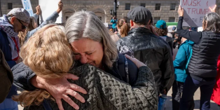 Lane Pollack, center, of Rockville, Md., a senior learning advisor at USAID for 14 years, is consoled by a co-worker after having 15 minutes to clear out her belongings from the USAID headquarters, Friday, Feb. 28, 2025, in Washington. (AP Photo/Jacquelyn Martin)
