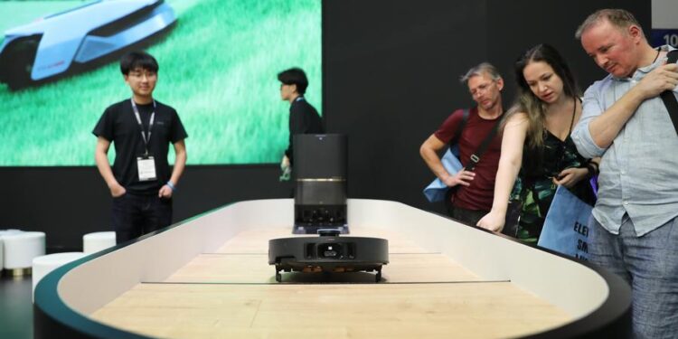 Visitors watch a floor cleaning robot at the booth of Dreame at IFA Berlin 2024 in Berlin, Germany, Sept. 7, 2024. (Xinhua/Du Zheyu)