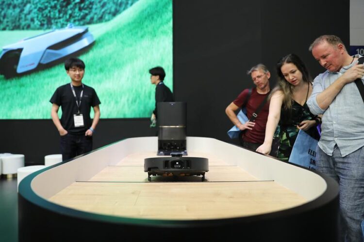 Visitors watch a floor cleaning robot at the booth of Dreame at IFA Berlin 2024 in Berlin, Germany, Sept. 7, 2024. (Xinhua/Du Zheyu)