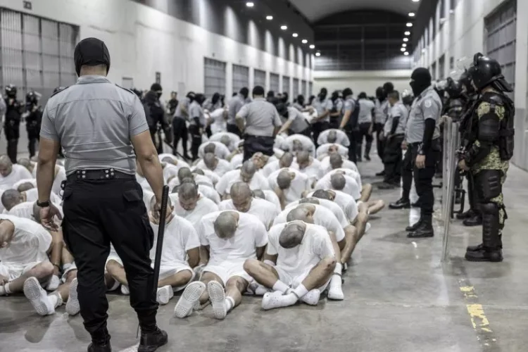 In this photo provided by El Salvador's presidential press office, a prison guard transfers deportees from the U.S. to the Terrorism Confinement Center in Tecoluca, El Salvador, on March 16. Associated Press