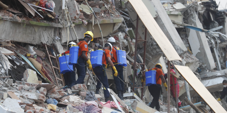 Members of a Myanmar rescue team spray water at the collapsed Sky Villa in Mandalay, Myanmar, March 31, 2025. /VCG
