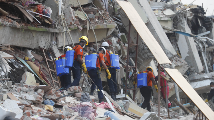 Members of a Myanmar rescue team spray water at the collapsed Sky Villa in Mandalay, Myanmar, March 31, 2025. /VCG