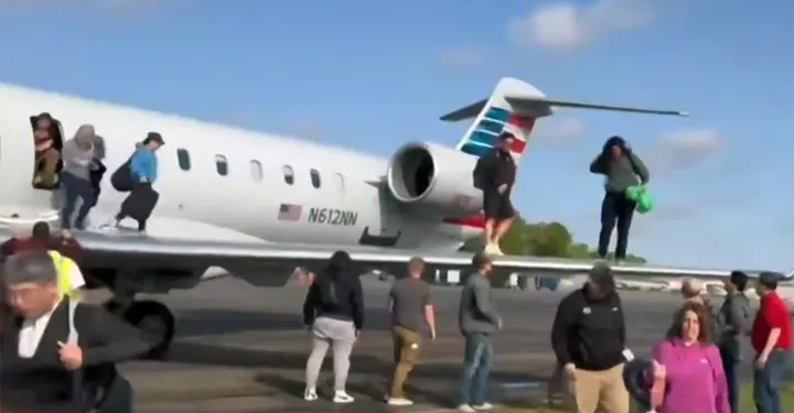Passengers are seen evacuating American Eagle Flight 5406 after it landed on Tuesday, April 1 at Augusta Regional Airport in Georgia. (APTN/Sean O'Conor)