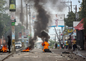 People walk past a burning barricade during a protest against insecurity, in Port-au-Prince, Haiti, on April 16 2025.
Image: REUTERS/Fildor Pq Egeder
