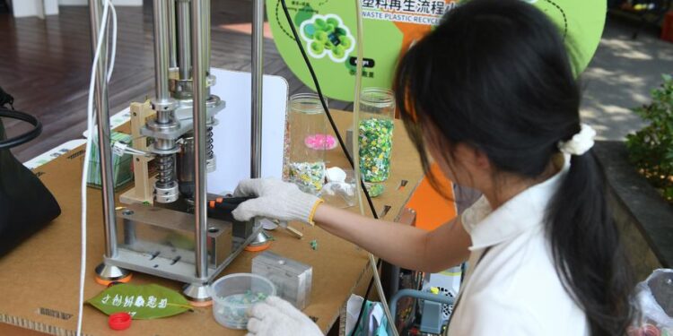 A staff member demonstrates the plastic recycling process at the Boao zero-carbon demonstration zone during the Boao Forum for Asia (BFA) Annual Conference 2025 in Boao, south China's Hainan Province, March 25, 2025. (Xinhua/Xie Ziyi)