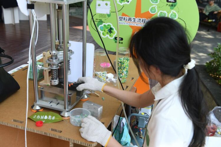 A staff member demonstrates the plastic recycling process at the Boao zero-carbon demonstration zone during the Boao Forum for Asia (BFA) Annual Conference 2025 in Boao, south China's Hainan Province, March 25, 2025. (Xinhua/Xie Ziyi)