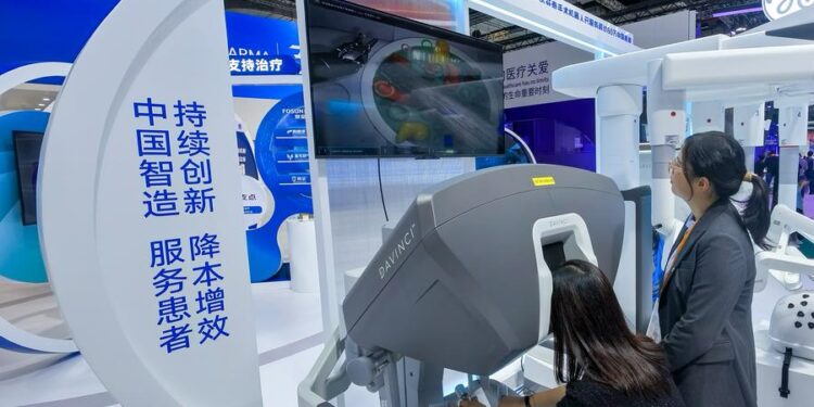 A visitor tries a surgery robot at the booth of Fosunpharma at the Medical Equipment & Healthcare Products Exhibition Area during the 7th China International Import Expo (CIIE) in east China's Shanghai, Nov. 8, 2024. (Xinhua/Zhang Cheng)