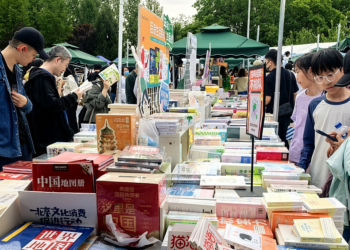 People visit a stall at a book fair in Beijing, capital of China, May 1, 2025. /VCG