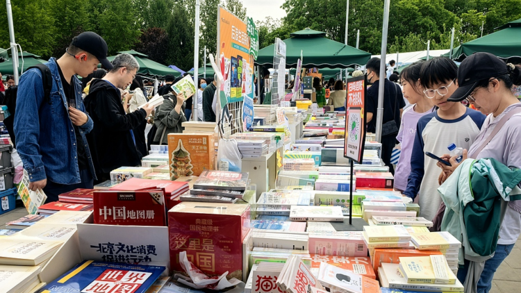 People visit a stall at a book fair in Beijing, capital of China, May 1, 2025. /VCG