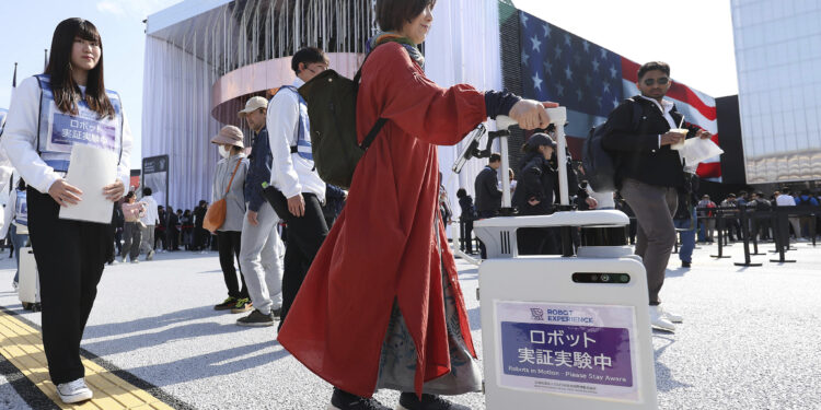 Participants experience the use of AI suitcase at a venue for Expo 2025 Osaka, Japan, April 14, 2025. /VCG