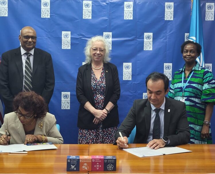 Signing of the agreement for electoral support.
Front Left to Right: Signatories - GECOM Chairman, Justice [ret'd) Claudette Singh and UNDP Resident Representative a.i., Berdi Berdiyev.
Back Left to Right: GECOM CEO, Vishnu Persaud, British High Commissioner H.E. Jane
Miller OBE and United Nations Resident Coordinator, Mean Njeri Kamau