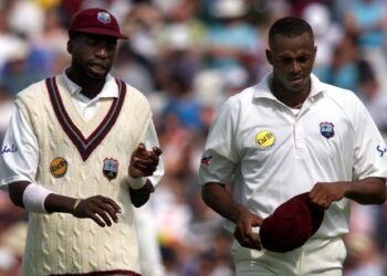 Sir Curtly Ambrose (L) and Courtney Walsh (R), of the West Indies, walk together during the first session of the Fifth Test against England at The Oval in London, 31 August 2000.