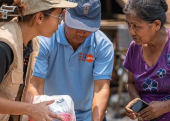 UNFPA Myanmar A UNFPA staff member distributes relief supplies to a woman affected by the March earthquakes in Myanmar.