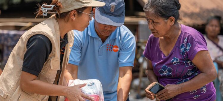UNFPA Myanmar A UNFPA staff member distributes relief supplies to a woman affected by the March earthquakes in Myanmar.