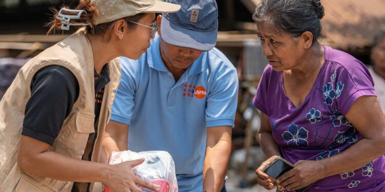 UNFPA Myanmar A UNFPA staff member distributes relief supplies to a woman affected by the March earthquakes in Myanmar.