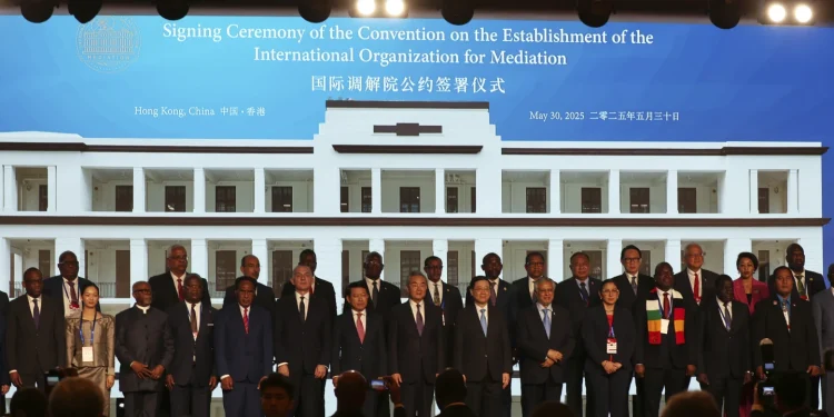 Chinese Foreign Minister Wang Yi, Center,  attends the signing ceremony of the "Convention of the Establishment of the International Organization of Mediation", in Hong Kong, Friday May 30, 2025 (AP Photo/Johnathon  Lee)