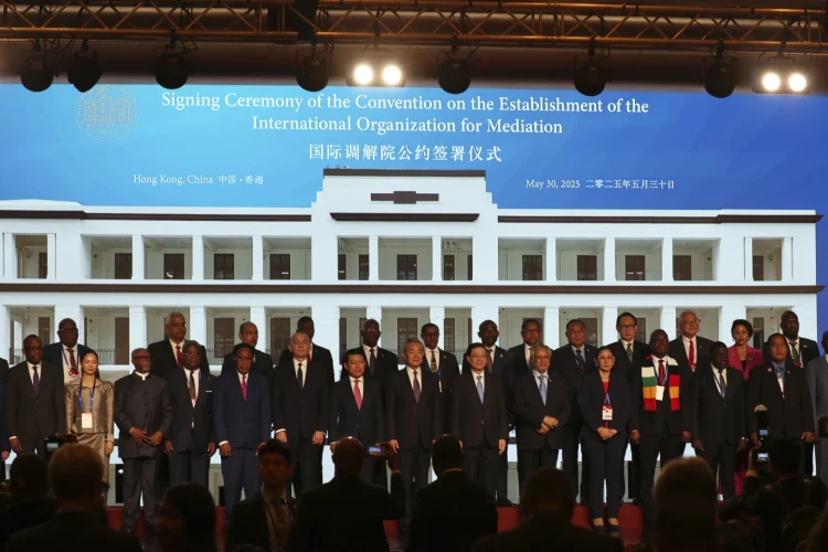 Chinese Foreign Minister Wang Yi, Center, attends the signing ceremony of the "Convention of the Establishment of the International Organization of Mediation", in Hong Kong, Friday May 30, 2025 (AP Photo/Johnathon Lee)