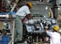 Two workers assemble a car at a manufacturing facility at Gurgaon, Haryana in India. Filephoto: VCG