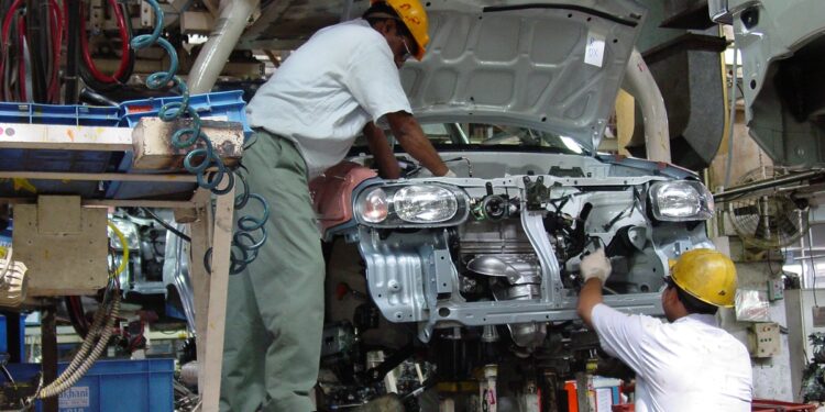 Two workers assemble a car at a manufacturing facility at Gurgaon, Haryana in India. Filephoto: VCG