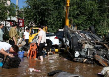 Villagers clean up their belongings on Tuesday as floodwaters recede in Taishitun township in Beijing's Miyun district. WU XIAOHUI/CHINA DAILY