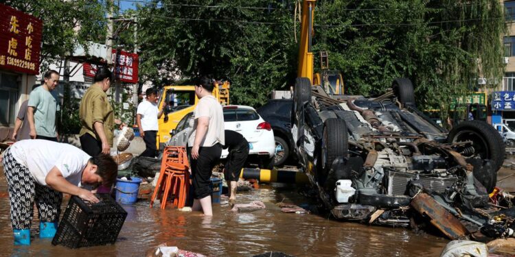 Villagers clean up their belongings on Tuesday as floodwaters recede in Taishitun township in Beijing's Miyun district. WU XIAOHUI/CHINA DAILY